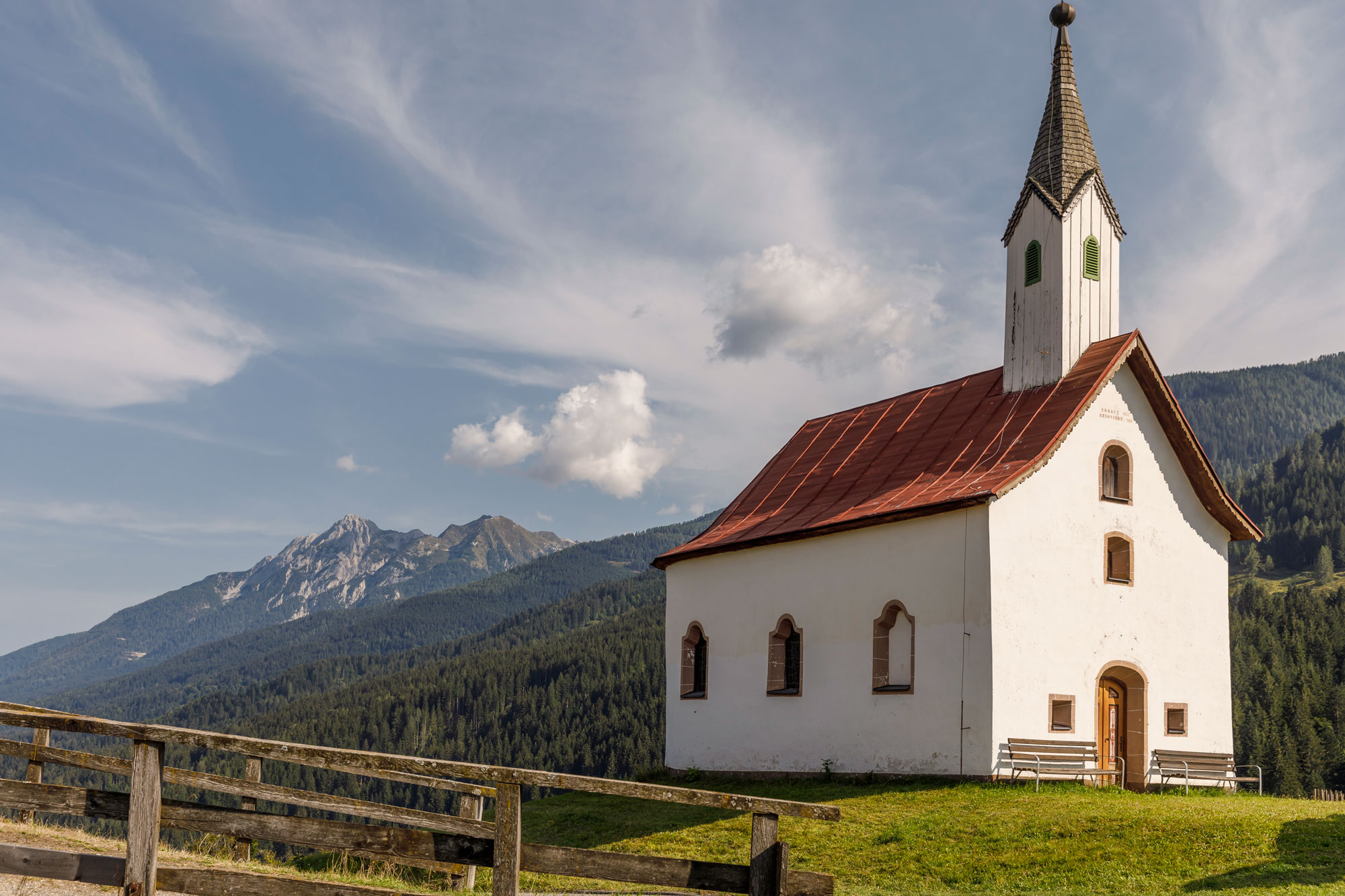 La cappella del maso davanti alle cime delle Alpi Carniche